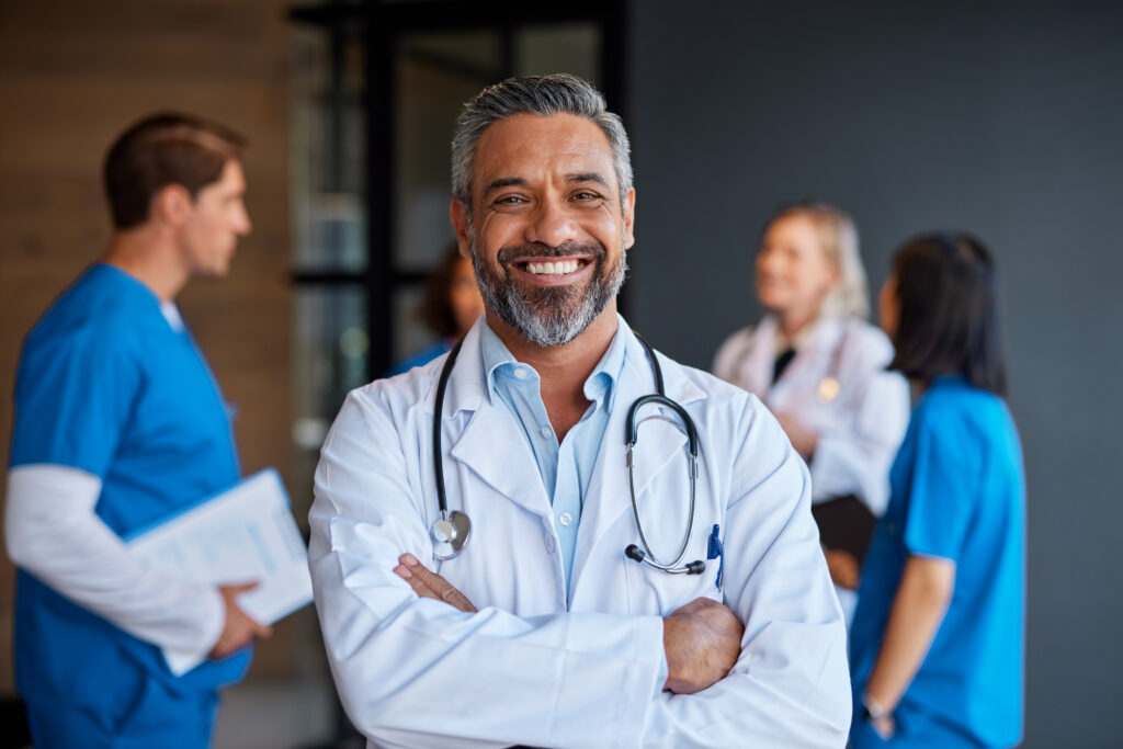 Portrait Of Smiling Mixed Race Doctor In Hospital - Cesanto Assessoria Empresarial | Escritório de Contabilidade na Zona Sul - SP
